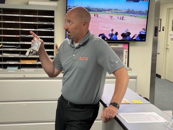 Athletic Director Collin Pregliasco stands in the athletic department’s office at Cosumnes River College, talking with a colleague on May 14. Pregliasco has been the director of athletics and dean of kinesiology, health and athletics since 2017.
