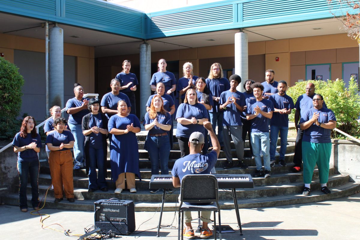 Omari Tau, a professor of vocal music, conducts the Contemporary Gospel Choir while accompanying them on piano in the Arts, Media and Entertainment Quad on Thursday. The choir performed pieces from their upcoming recitals on Oct. 17 at 7 p.m. as part of the CRC Music Student Spotlight event. 