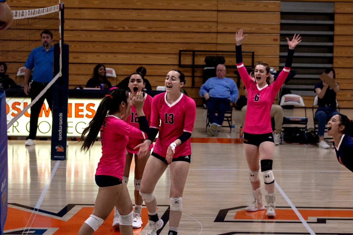 The volleyball team celebrates freshman outside hitter Kaylie Reyes’, far left, game-winning point against Modesto Junior College on Oct. 23. The Hawks improve to a 6-7 record within the Big 8 Conference and 14-10 overall this season.