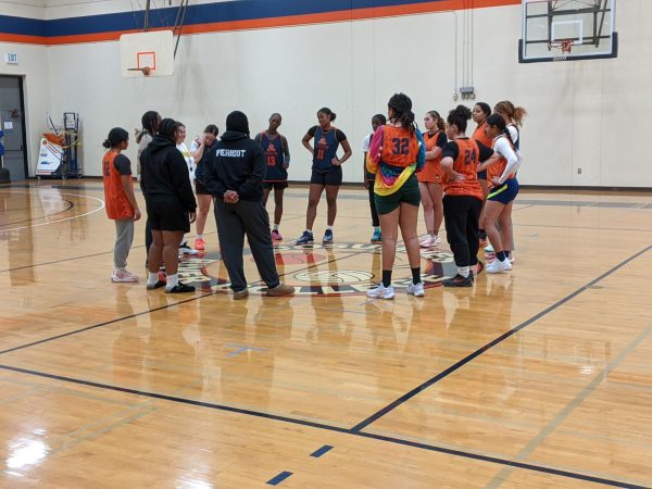 The women’s basketball team gathers in a final huddle before the end of practice. The Hawks currently have a 4-3 overall record.