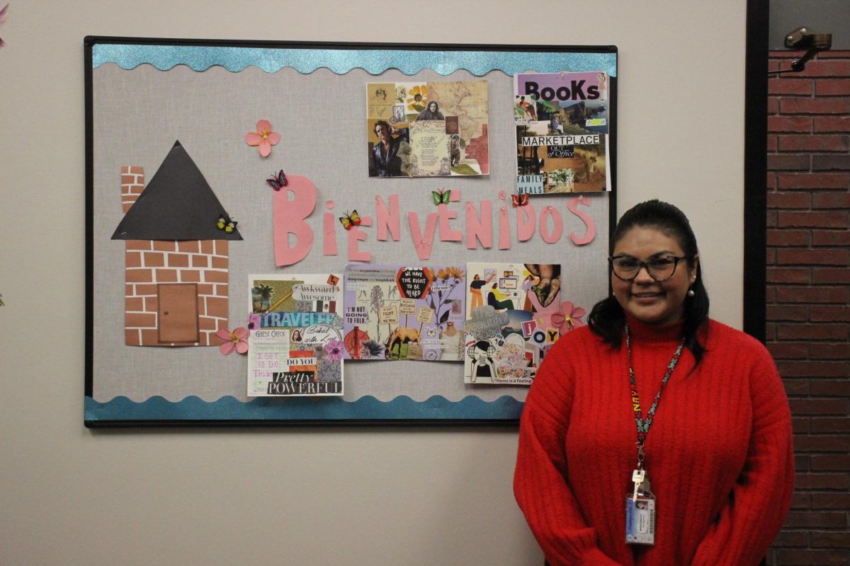 New MI CASA director Melissa Sanchez stands in front of a welcome poster saying “Bienvenidos” near the entrance of the program’s space, in L-309. Sanchez said being the director is her dream job, and works to support students as they navigate college life. 